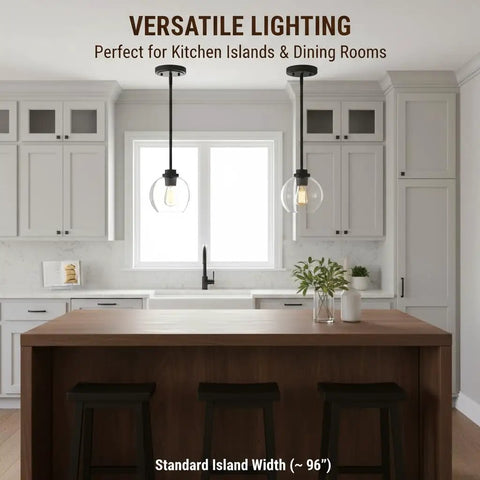 Straight Up Matte Black Globe Pendant Lights 2 Pack With Clear Glass Shades installed over a kitchen island in a modern kitchen.