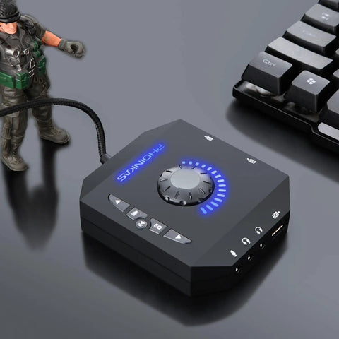 External USB Sound Card 7.1 Channel Audio Adapter with 3.5mm interface next to a keyboard and toy figure on a desk.