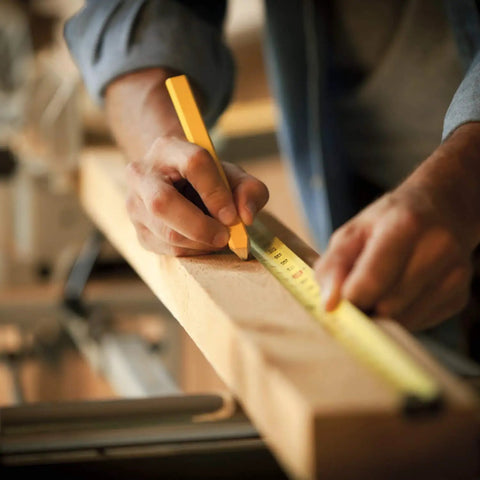 Person measuring wood with 25 Ft Measuring Tape With Easy Read Decimal Scale, Dual Sided Ruler In Metric And Inches, Magnetic Tip