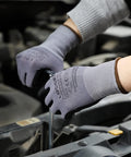 Pair of safety work gloves, gray seamless knit with micro-foam nitrile coating, worn while inspecting car engine