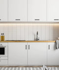 Modern kitchen with Matte Black Square Cabinet Pulls 5 Inch 30 Pack Handles installed on white cabinets and drawers.