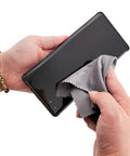 Xthel microfiber cleaning cloth; close-up of hand wiping smartphone screen with gray cloth