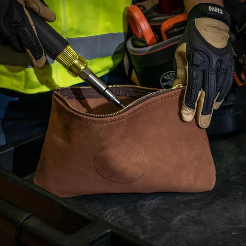 Person placing a screwdriver in a Top-Grain Leather Tool Pouch With Zipper Closure 12.5 Inch Brown Built Tough For Pliers And Wrenches