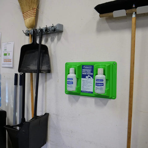 PhysiciansCare wall-mount emergency eyewash station, green, with two 32 oz eyewash bottles and instruction panel.