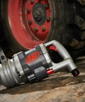 Heavy Duty 1 1/2 Inch Air Impact Wrench With D Handle resting on the ground, showcasing rugged design for tough garage work.