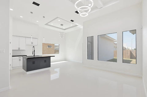 Modern kitchen concept with white cabinets, black island, and sleek ceiling AC vents showcasing a clean, stylish interior.