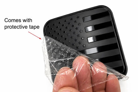 American Flag Trailer Hitch Plug Cover For 2 Inch Receiver Built To Last Tough As Nails Heavy Duty Weather Resistant Tow Hitch Protector Durable Black Metal Shield with protective tape being removed
