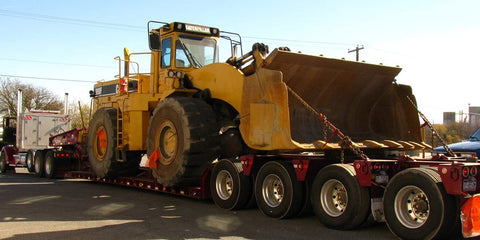 Beefed Up Heavy Duty Chain Binder Kit With Three Eighths Inch By Ten Foot Chains securing loader on trailer for transport