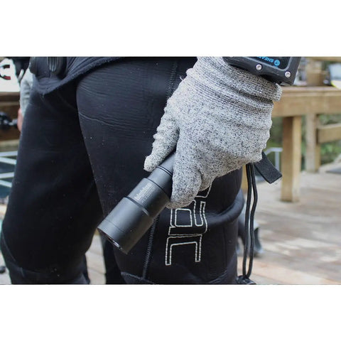 Scuba diver holding a 1300 Lumen Narrow Beam Dive Light With Tail Switch For Scuba And Snorkeling, waterproof design
