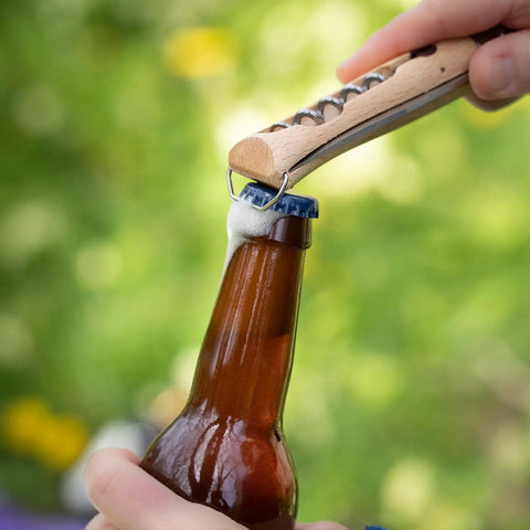 Nomad Camping Kitchen Utensil Kit With Serrated No 12 Folding Knife No 10 Corkscrew Knife No 6 Peeler And Cutting Board opening a bottle