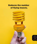 Hand holding Yellow Spiral CFL Bulb on yellow background with text 'Reduces the number of flying insects', focus keyword not applicable