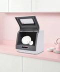 Hassle-Free Countertop Dishwasher With A Slick Stainless Steel Interior, Portable Kitchen Workhorse by a pink countertop.