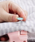 No Sweat Heavy Duty Handheld Sewing Gun Quick Clothing Repair Tool Featuring Pink Grip applying a plastic pin on fabric.