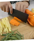 LIFKOME wavy cutter for vegetables and fruits, stainless steel crinkle slicer; hands slice carrot and potato on a wooden board