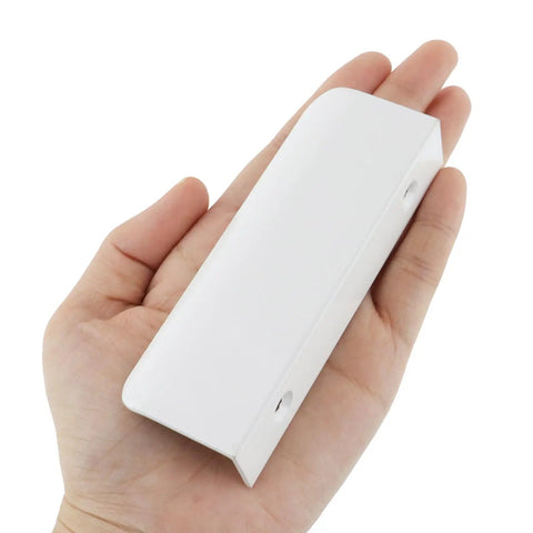 Person holding a White 3.94 Inch Curved Edge Finger Pulls 10 Pack For Cabinets And Dressers 64mm Hole Centers Aluminum Alloy Back Mount Concealed Handles