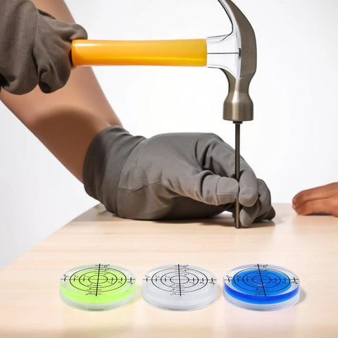 Round Bubble Level 32mm 12 Pack Circular for spirit Levels for acrylic with hammer and two vibrant levels on a wooden surface.