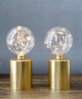 Large Cage Table Lamp Battery Powered With Double Metal Mesh And Edison Bulbs 8W X 10H on a wooden surface with glowing bulbs