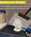Portable Model Making Workbench With LED Lights And Magnifier All In One Cutting And Assembly Kit For DIYers Includes Pliers Holder Gridded Adhesive Cut Mats Plastic Storage Drawers Display Panel top view with magnifier and tools.