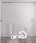 White Plastic Refrigerator Door Stopper Hook Replacement Catch on snowy freezer background for secure fridge closure.