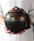 Super Sleek Large Ceramic Tea Canister With Airtight Lid For Loose Tea Leaves Coffee Beans And Candy Kitchen Food Storage Jar, unique design, held by hands.