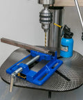 3 Inch Heavy Duty Drill Press Vise Portable Bench Clamp With Slotted Base And Serrated Steel Jaws on a drill press, holding a metal piece.