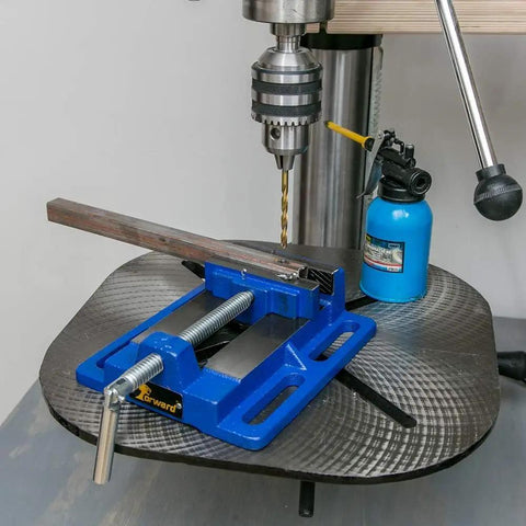 3 Inch Heavy Duty Drill Press Vise Portable Bench Clamp With Slotted Base And Serrated Steel Jaws on a drill press, holding a metal piece.