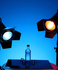 Heavy Hitter Seven Inch Barn Door Lighting Kit With Adjustable Honeycomb Grid And Four Pumped Up Color Gel Filters For Dialing In Crisp Beams On Standard Studio Flash Heads, showcasing blue and red light with vodka bottle.