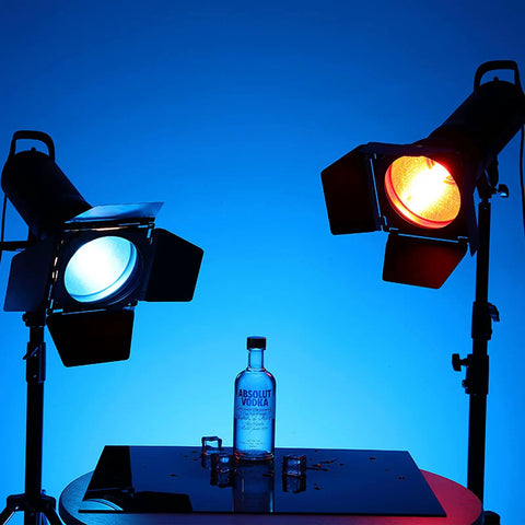 Heavy Hitter Seven Inch Barn Door Lighting Kit With Adjustable Honeycomb Grid And Four Pumped Up Color Gel Filters For Dialing In Crisp Beams On Standard Studio Flash Heads, showcasing blue and red light with vodka bottle.