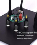 Adjustable Soldering Helping Hands with four magnetized pillars and flexible arms holding a PCB on steel base for precise assembly.