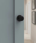 Cove Keyed Entry Door Knob With Lock And SmartKey Security Matte Black Exterior doorknob on blue door indoors
