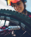 Person using Twin Speed CO2 Inflator Bike Repair Kit with Lever on mountain bike tire with 16g twin cartridge.
