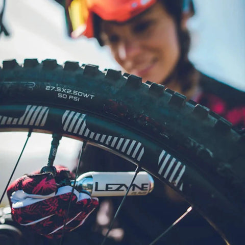 Person using Twin Speed CO2 Inflator Bike Repair Kit with Lever on mountain bike tire with 16g twin cartridge.