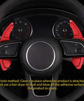 Close-up of Audi steering wheel with Two Piece Aluminum Alloy Shift Paddle Extensions For Audi A3 A4L 2013 2016 And A5 2012 2016 Bright Red Interior Accent Upgrade With CNC Machined Precision Fit And Non Slip Grip For A Sporty Driver Feel.