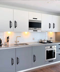 Modern kitchen with matte black cabinet handles on white and gray cabinets, showcasing 12 Pack Matte Black Cabinet Handles Aluminum Drawer Pulls.