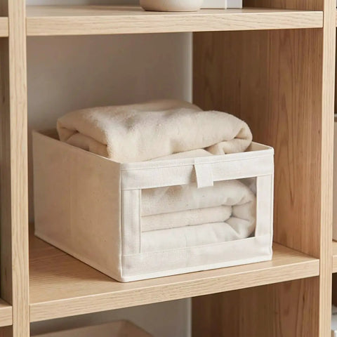 Heavy Duty Cotton Linen Foldable Storage Bins Stackable Closet Organizers with blankets stored in a beige fabric bin on a shelf.