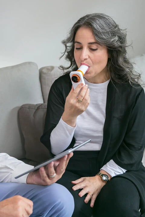 Personal Pocket Peak Flow Meter With Smartphone App For Home Lung Function Monitoring PEF And FEV1 Readings Sync Results To Your Health Care Provider No Prescription Needed Easy To Use woman testing breathing at home