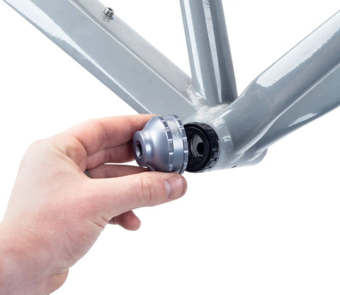 Hand using 16 Notch Bottom Bracket Tool For Quick Removal And Installation Fits Shimano Ultegra BBR60 And Deore XT MT 800 on bike frame