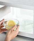 Person placing lemon bowl in microwave with Waveguide Cover Ten Pack For Microwave Ovens, Mica Sheets 5.9 By 4.7 Inches visible inside.