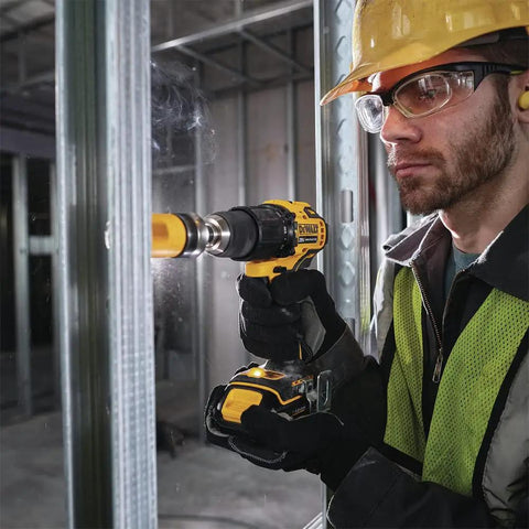 Worker using Atomic 20V Max Cordless Hammer Drill With 1/2 Inch Chuck in tight space with LED foot light for visibility.