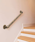 Heavy Duty Industrial Staircase Handrails 3 Ft Galvanized Pipe mounted on a wall beside wooden stairs for indoor use.