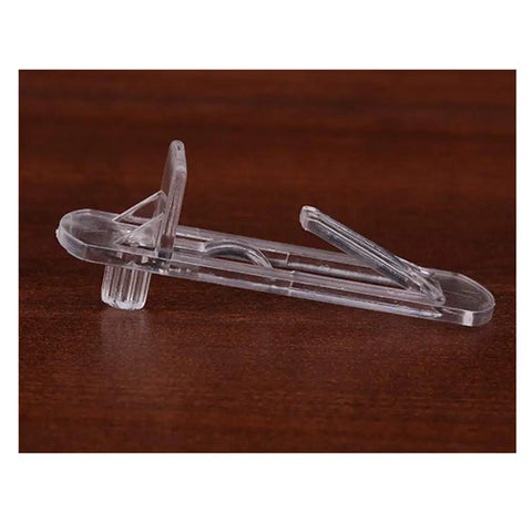 Single clear plastic locking shelf pin on wooden background, part of Twenty Piece Set Self Locking Plastic Shelf Pins And Clips For Four Point Nine Millimeter Hole Size And Three Fourth Inch Thick Shelves Fits Kitchen Cabinets And Book Shelves Easy To Install.