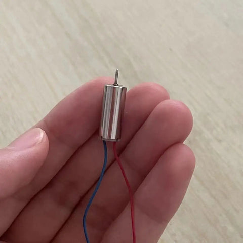 Hand holding a 716 And 614 Hollow Cup Drone Propellers For RC Aircraft Quadcopters Spare Parts Kit with micro motor.