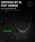 Straight Up Fast 54.6V 2A Ebike Charger For 48V Lithium Battery Quick Charge Adapter with UL certification beside a bike wheel.