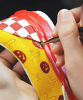 Close-up of applying White Acrylic Leather Paint 1 Fl Oz Flexible Crack Scratch Peel Resistant to a sneaker with colorful designs.