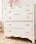 White dresser with pink butterfly-shaped gold cabinet knobs set for dresser drawers and closets, decor view.