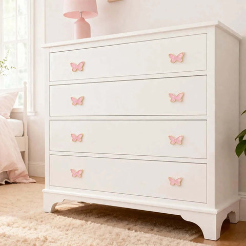 White dresser with pink butterfly-shaped gold cabinet knobs set for dresser drawers and closets, decor view.