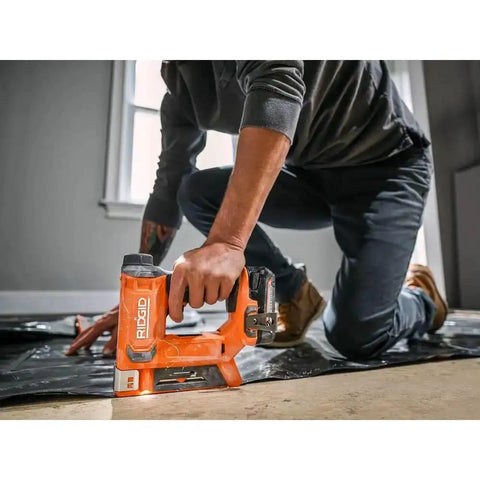 18V Cordless Crown Stapler With Three Eighth Inch Heavy Duty Fasteners And Two Point Oh Amp Hour Battery Charger Kit Featuring Dry Fire Lockout LED Spotlight in use on floor.