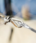 Close-up of Ten Pack Eye Bolts One Quarter Inch By Four Inch Stainless Steel With Nuts securing outdoor cable.