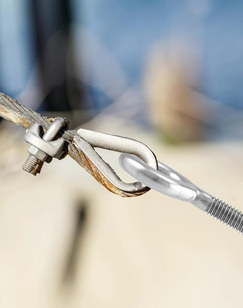 Close-up of Ten Pack Eye Bolts One Quarter Inch By Four Inch Stainless Steel With Nuts securing outdoor cable.