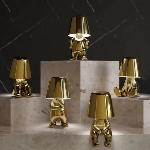 Gold Decor Thinker Statue Bedside Table Lamp With USB Port, Touch Control LED Night Light showcased in a group on steps.